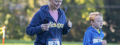 Mother and son jog outdoors during the 2018 Bramble Ramble 5k Trail run/walk at Montcalm Community College in Sidney, MI.