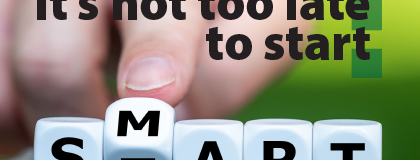 Black text, "It's not too late to start." Hand with pointer finger flipping a white die with letters M and T. Other dice in a row read S, A, R, T.