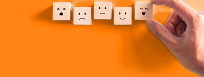 Five square blocks with basic facial features against orange background.