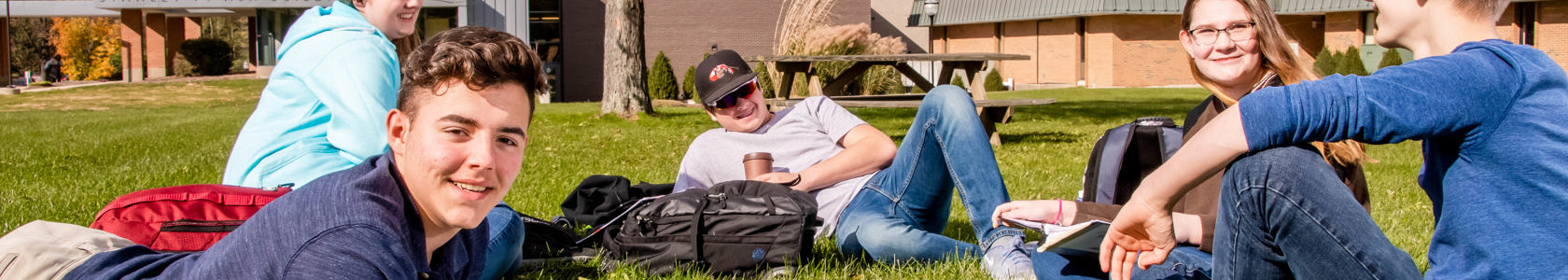 Early college students in a grassy lawn.