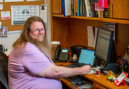 Man with long beard sitting at desk