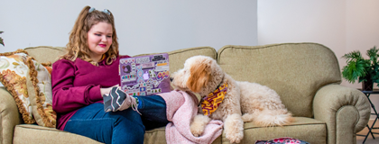 Emma Skogseth and her goldendoodle learning on Emma's couch.