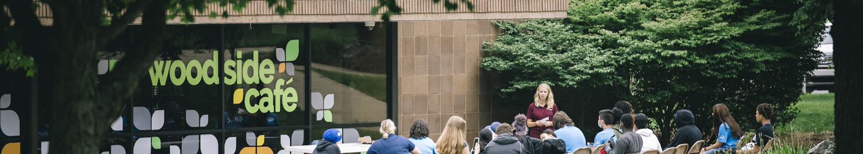 students on picnic tables outside of the woodside cafe