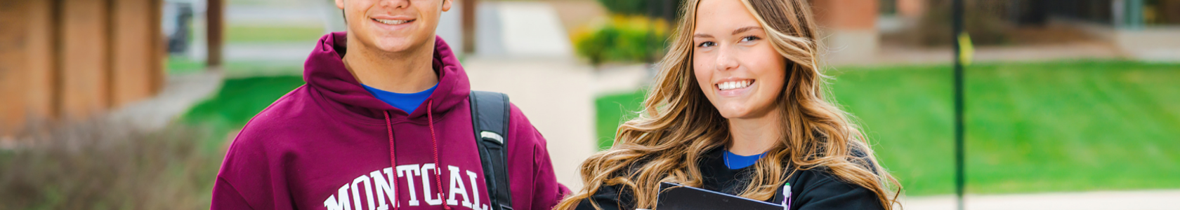 Male and female college student standing outside