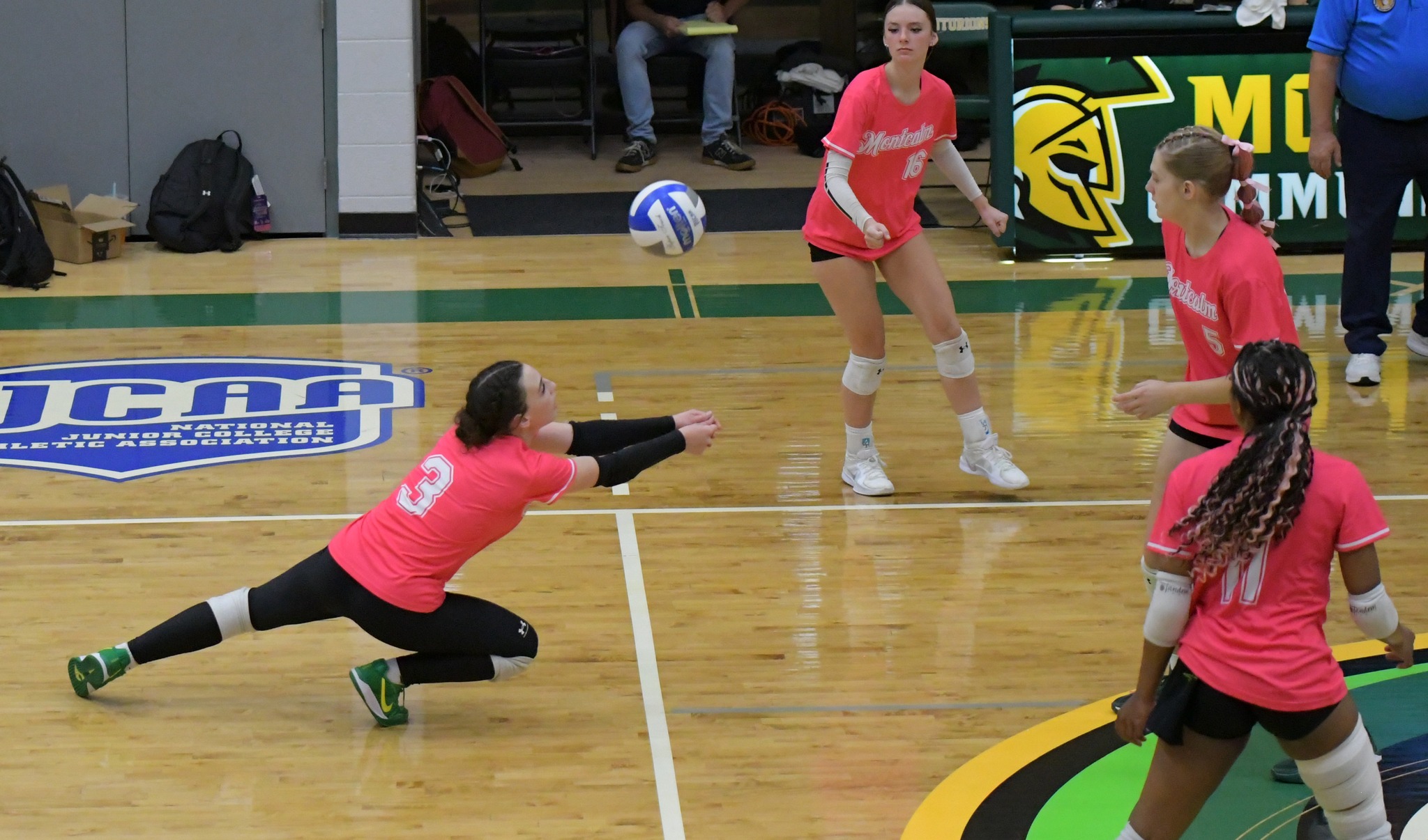 MCC volleyball player dives to bump an incoming ball on the court.